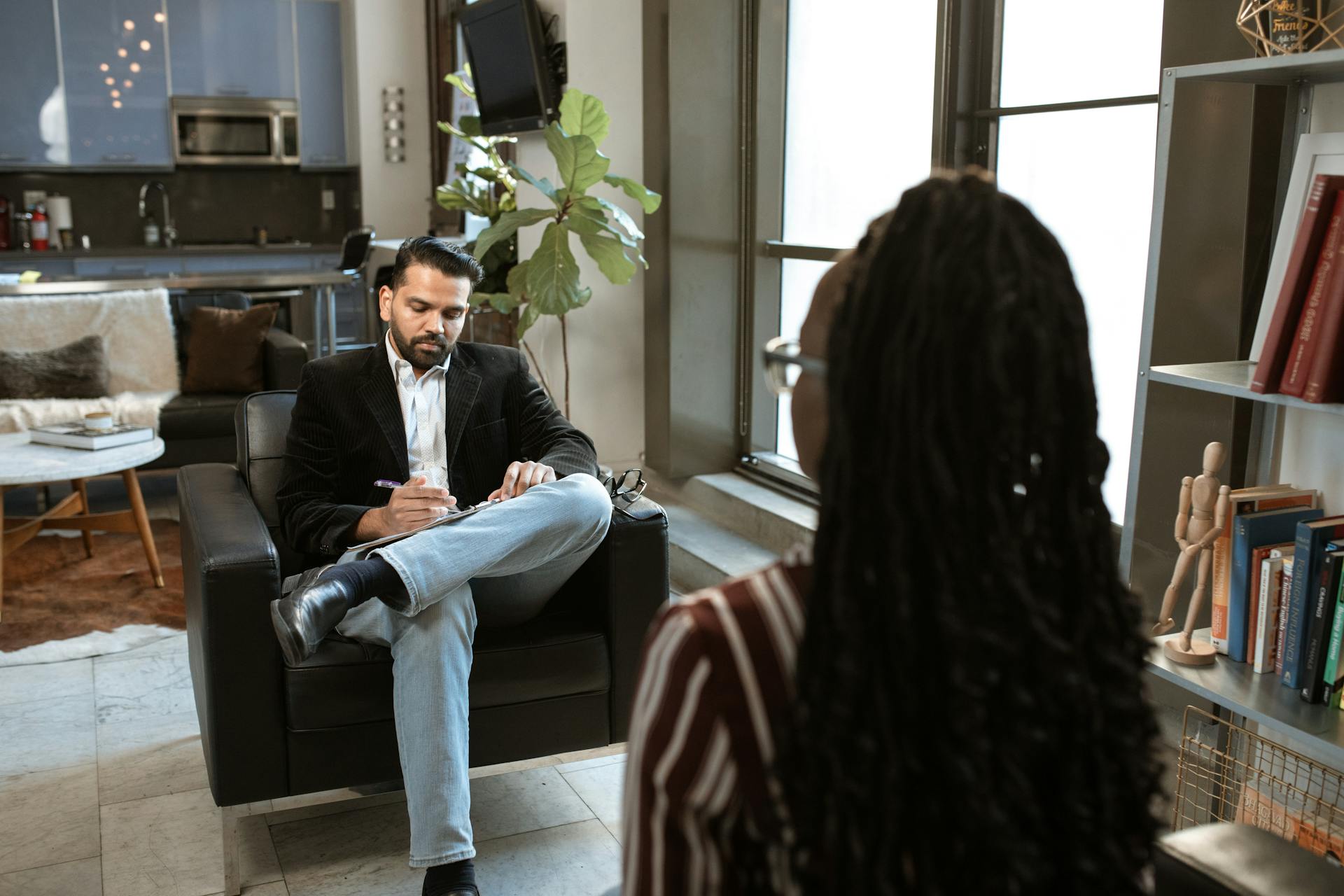 A business professional conducts a job interview in a stylish, modern office space.