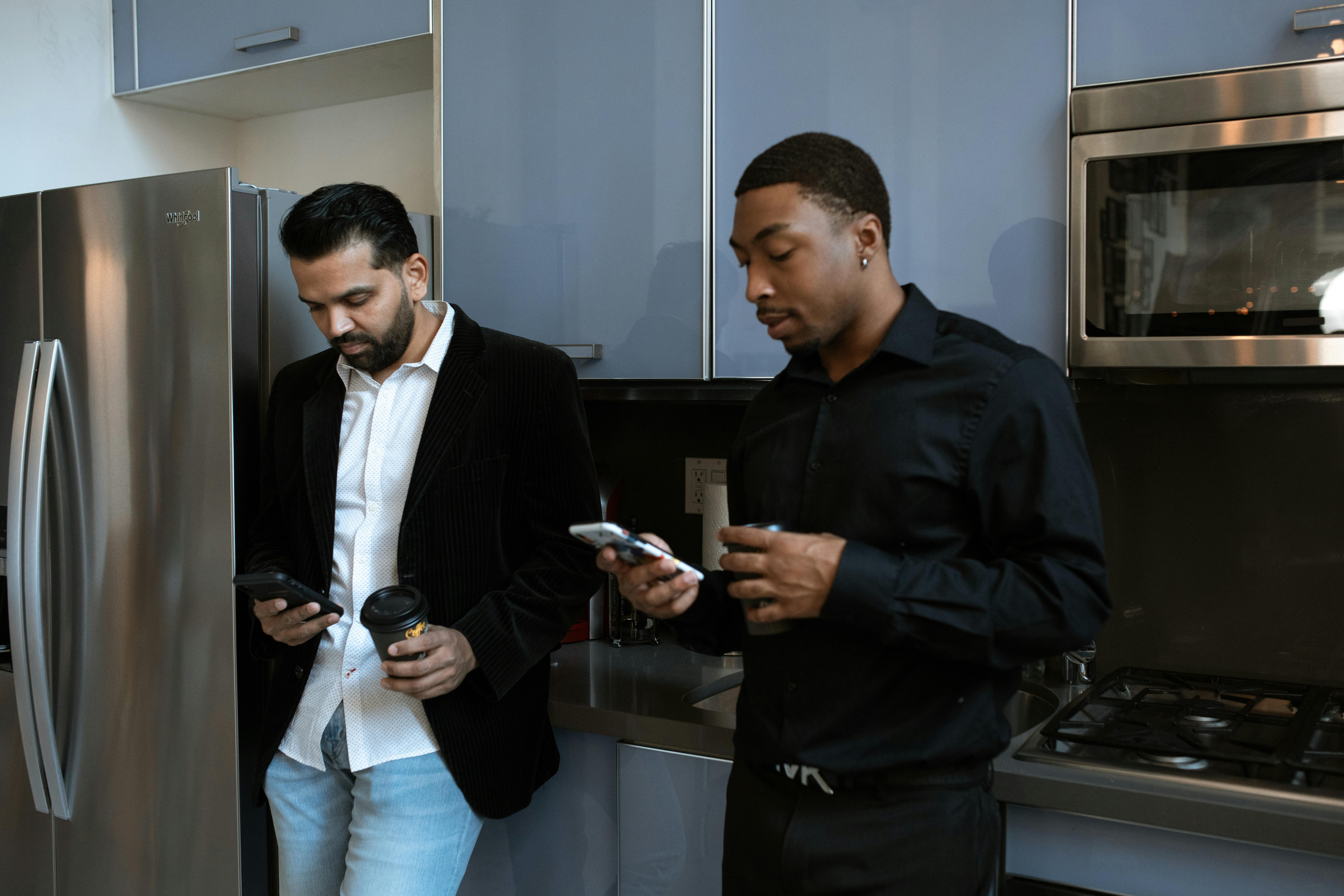 man in black dress shirt holding smartphone