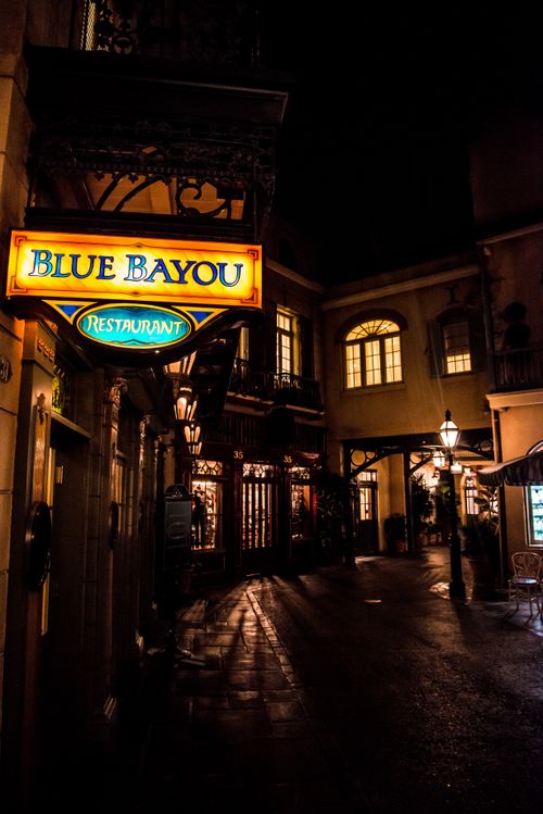 Free Night view of Blue Bayou Restaurant's illuminated sign in Disneyland, showcasing charming architecture and ambient lighting. Stock Photo