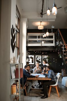 A diverse group of professionals collaborate in a stylish, modern coworking space with loft design.