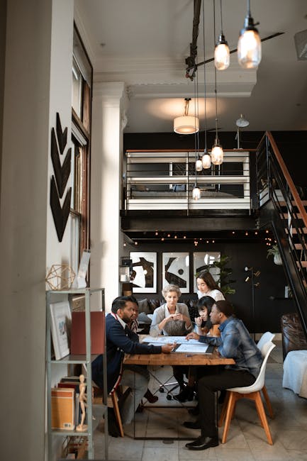 A diverse group of professionals collaborate in a stylish, modern coworking space with loft design.