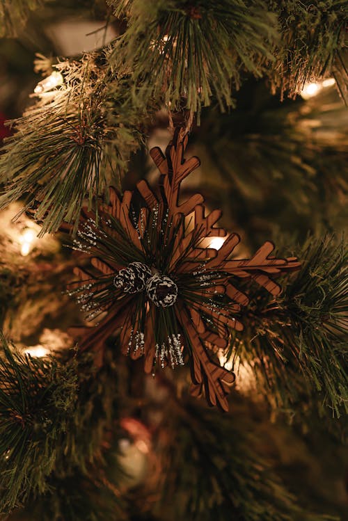 Christmas tree decorated with wooden snowflake bauble and garlands