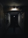 Person Standing in a Hallway in a Dark Room
