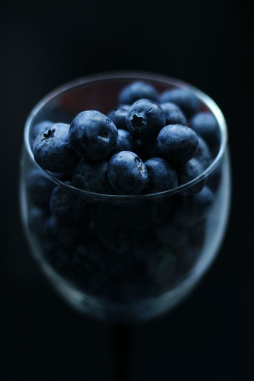 Free Fresh blueberries in a glass set against a dark background, emphasizing their rich color and texture. Stock Photo