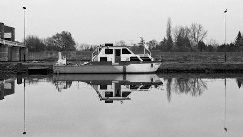 Grayscale Photo of a Boat in the Lake