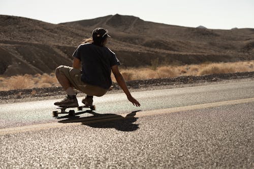 Free Man Riding a Longboard n the Road Stock Photo