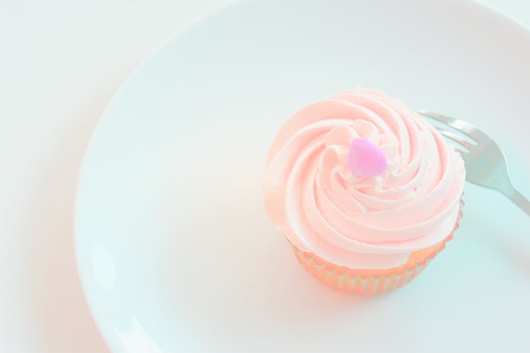 White Icing-covered Cupcake On Plate