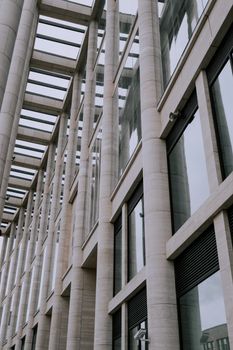 当代建筑通过玻璃窗和石柱的外观设计，展示了其建筑设计理念