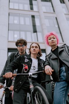 三位时尚的年轻人在城市环境中与自行车合影，展现出都市的时尚与活力
