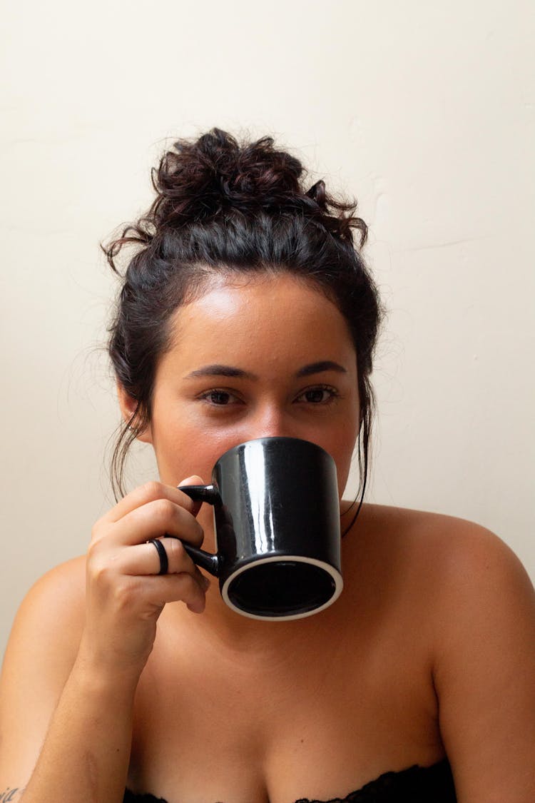 Beautiful Woman Drinking From A Black Mug