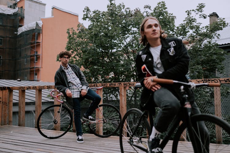 Two Men Seated On Bicycles