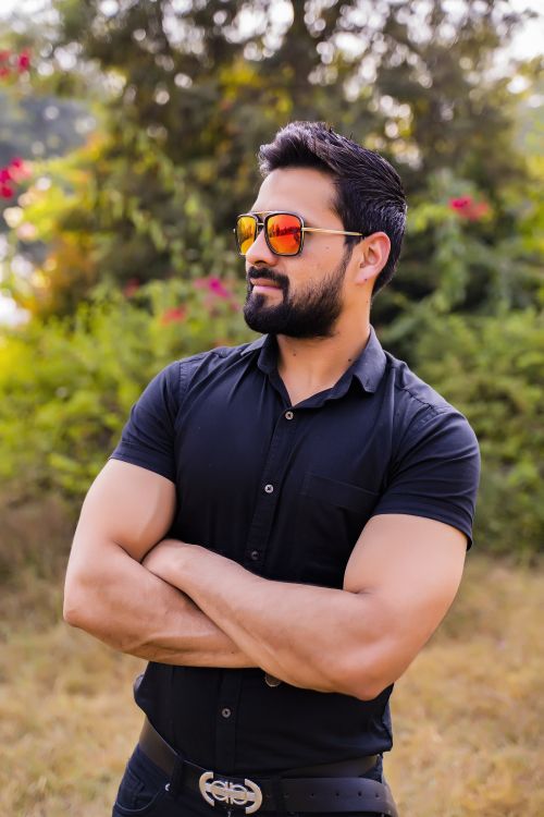 Free Confident man in sunglasses with crossed arms standing outdoors. Ideal for lifestyle and fashion content. Stock Photo