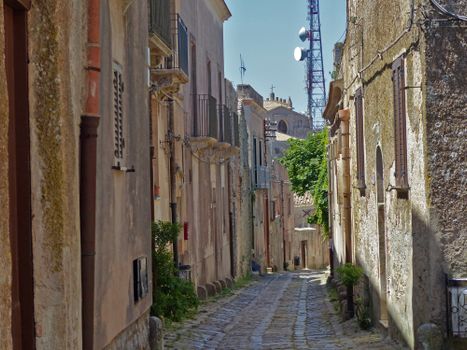 Charming cobblestone street in historic Sicilian town with distinct architecture and rustic charm.