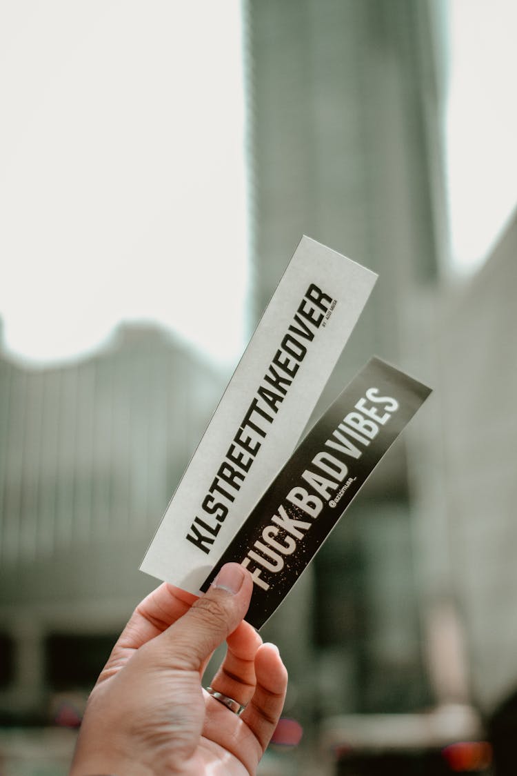 Person Holding White And Black Printed Materials