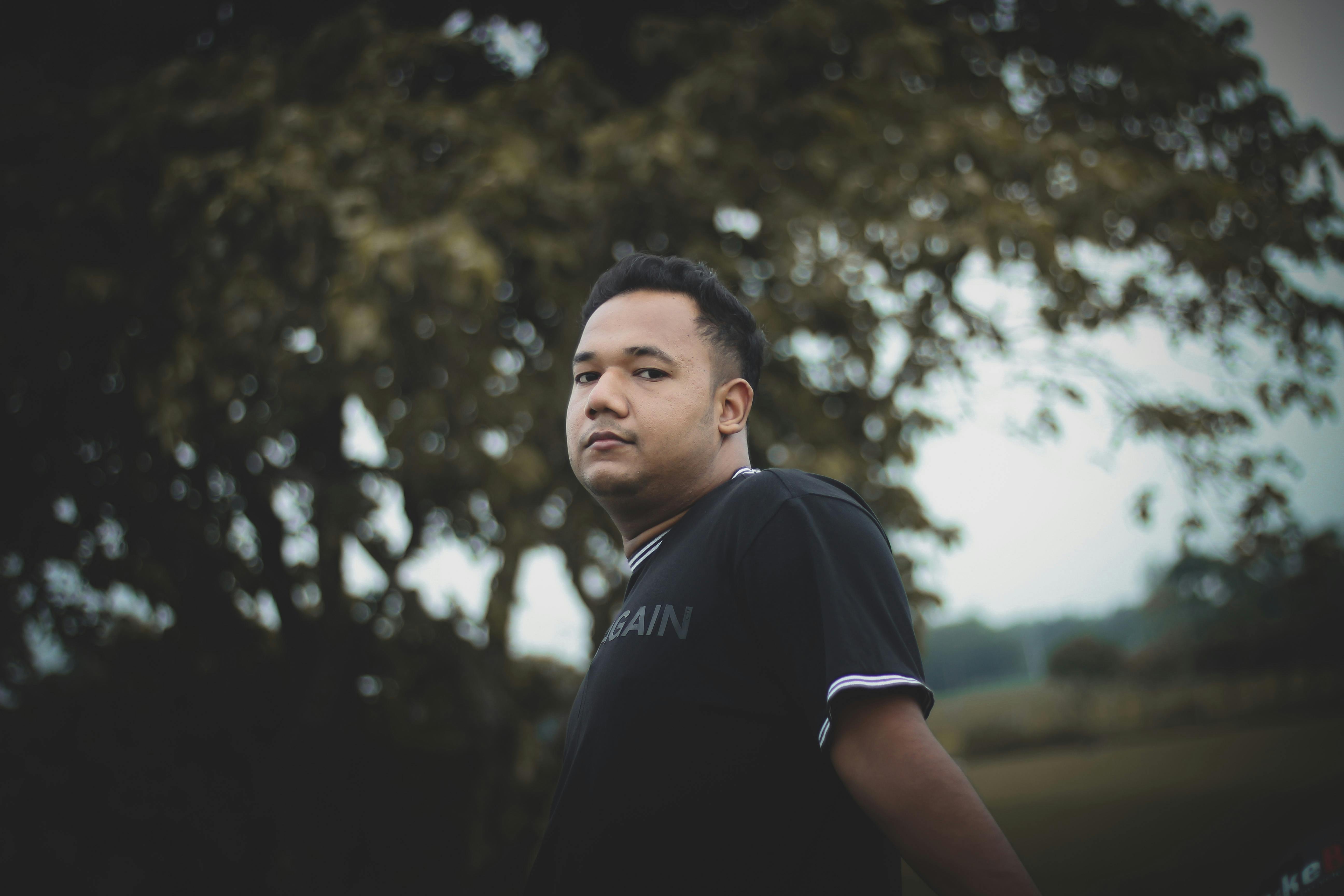 Person holding a multivitamin tablet over a plate of healthy food