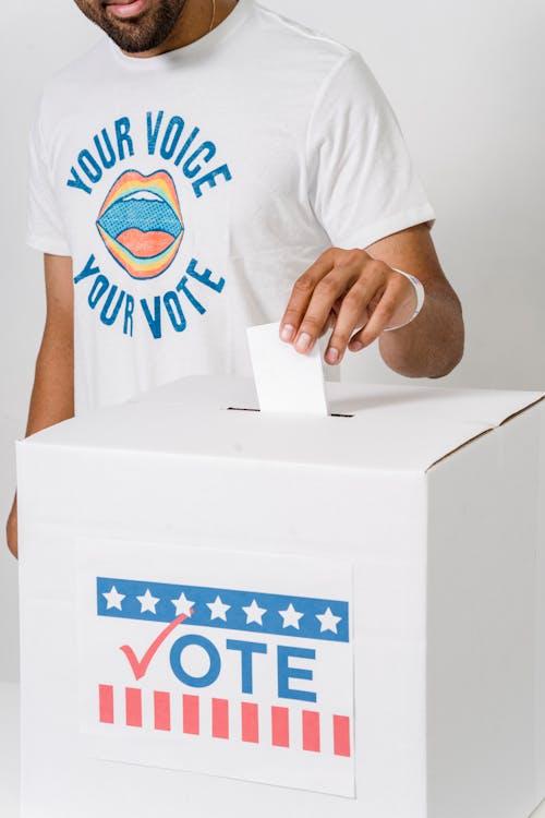 A Person Dropping His Vote in White Box