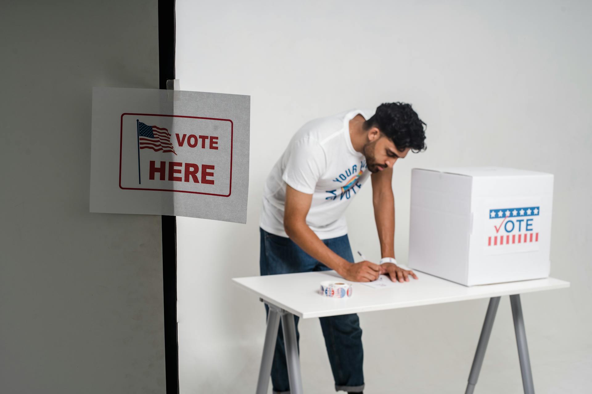 A Man Voting beside a Ballot Box