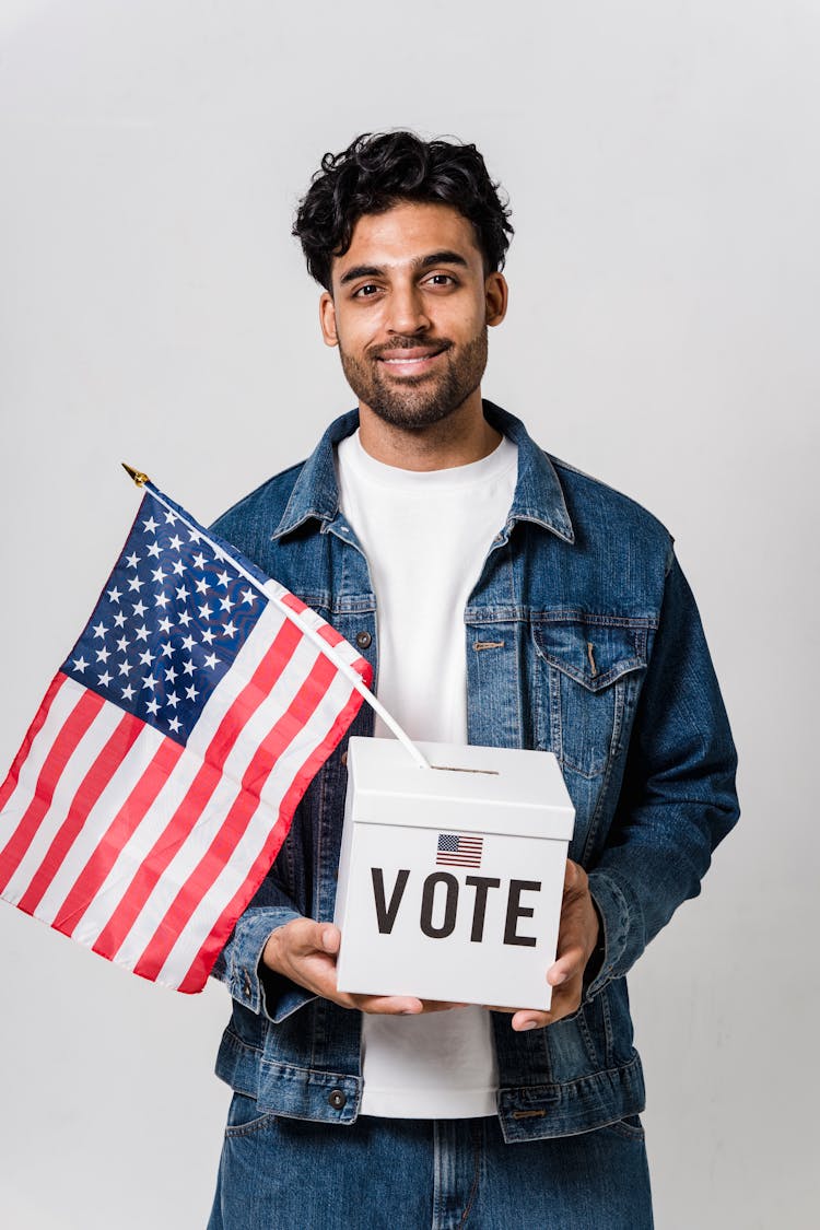 A Man Carrying A Ballot Box