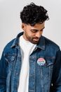 A Man Wearing a Denim Jacket while Looking Down