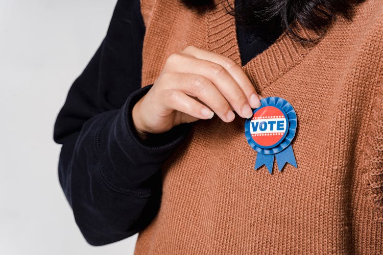 A Person With Vote Pin On Vest