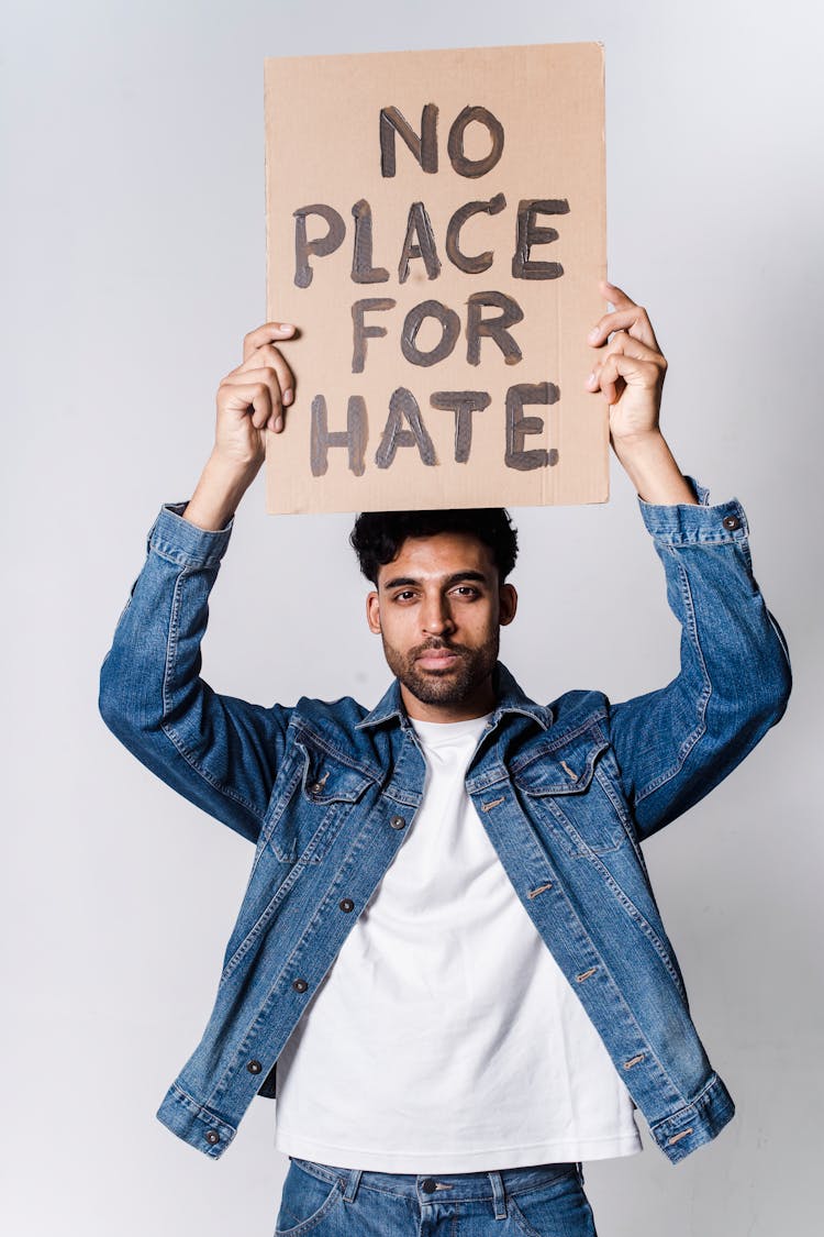 A Man Holding A Placard Above Head