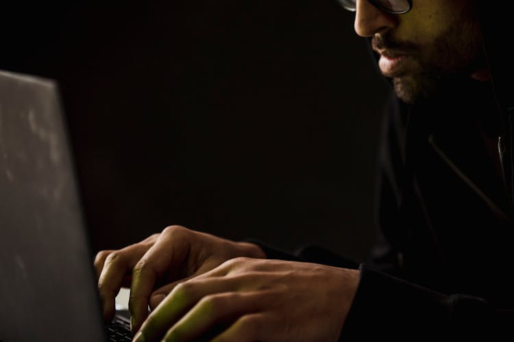 Crop Bearded Man Working On Laptop In Darkness