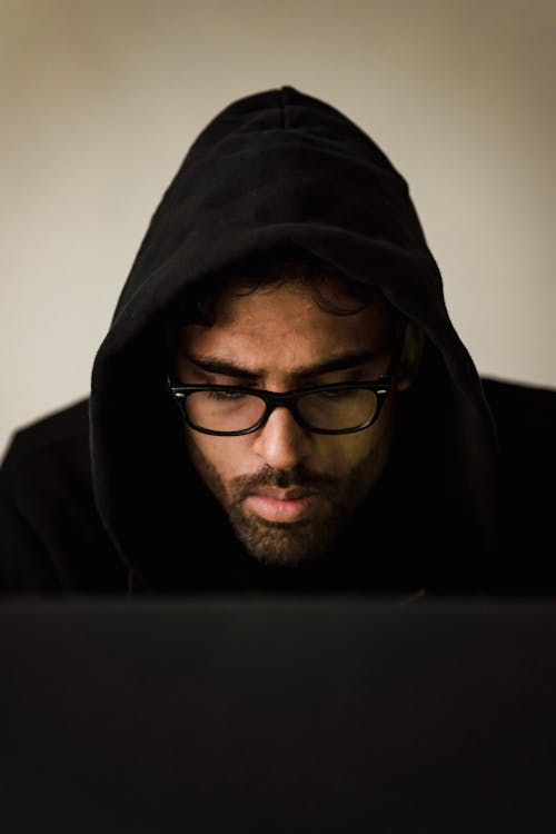 Serious hacker using laptop in studio