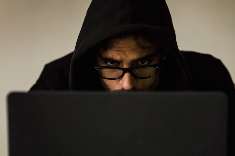 Notoriti AI Cybersecurity3 Notoriti generative AI cybersecurity hooded figure laptop dark room