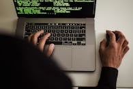 Crop faceless programmer working on laptop in studio