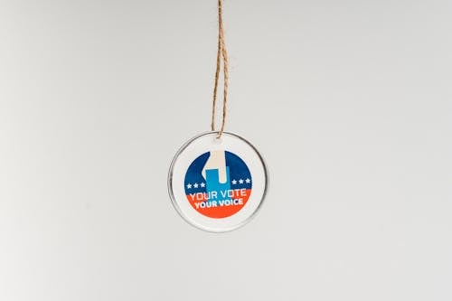 Close-up of a Pendant with a Text Saying "Your Vote Your Voice"