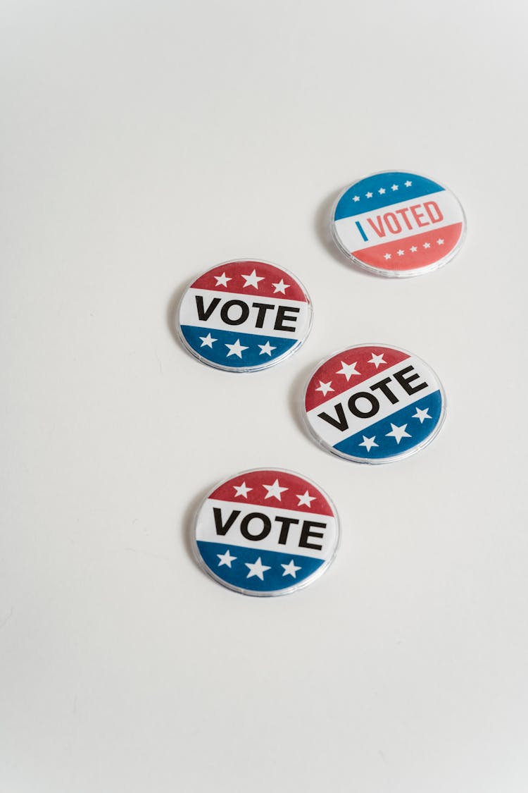 Vote And I Voted Pin-Back Buttons On A White Surface