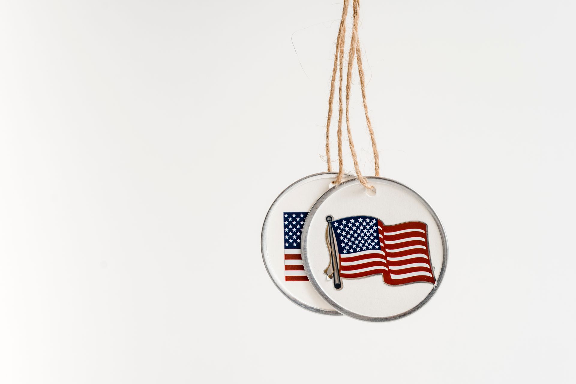 Close-up of two hanging pendants featuring the American flag with copy space on a white background.