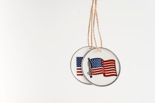 Free Close-up of two hanging pendants featuring the American flag with copy space on a white background. Stock Photo