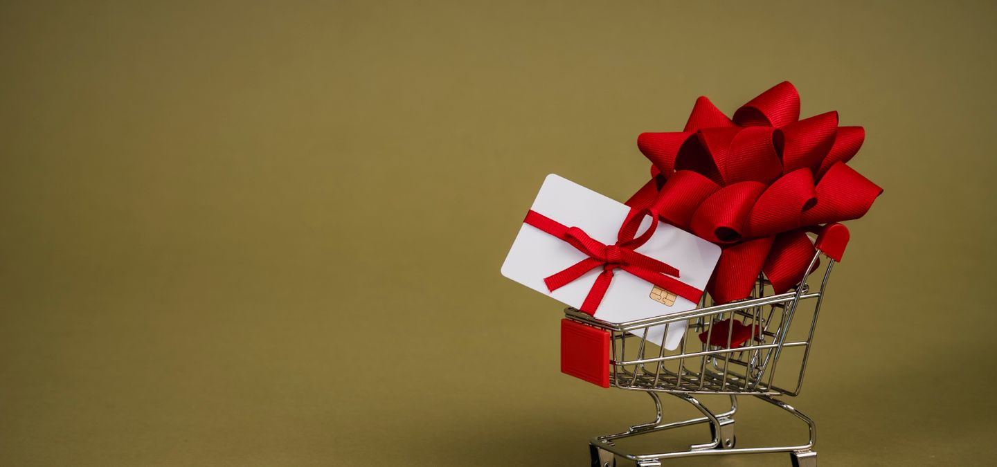 Gift card with a red bow in a small shopping cart