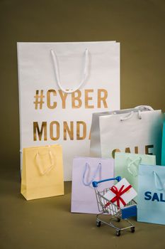 Colorful shopping bags and a mini cart for Cyber Monday sales.