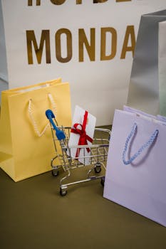 Mini shopping cart with bags and gift card, representing Cyber Monday shopping concept.