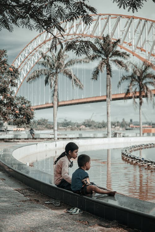 Kids Sitting Near the River