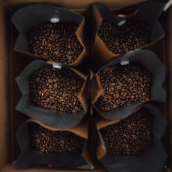Overhead shot of coffee beans packed in brown paper bags, showcasing rich texture and freshness.