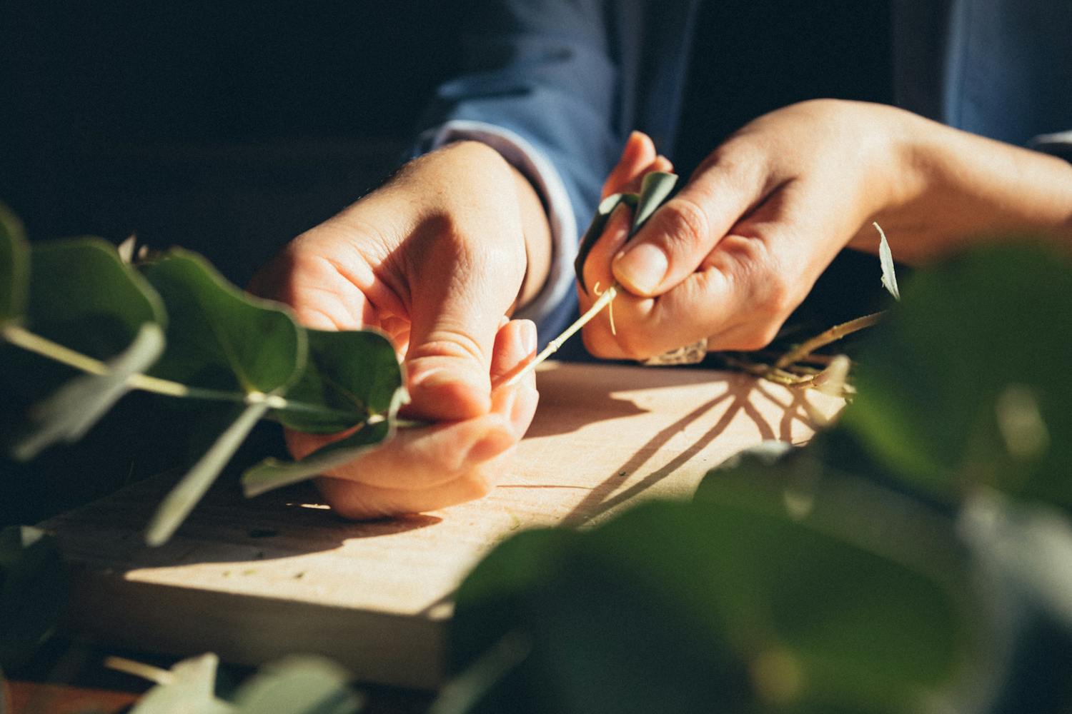 Hands of artisan working with natural sustainable materials on wooden table