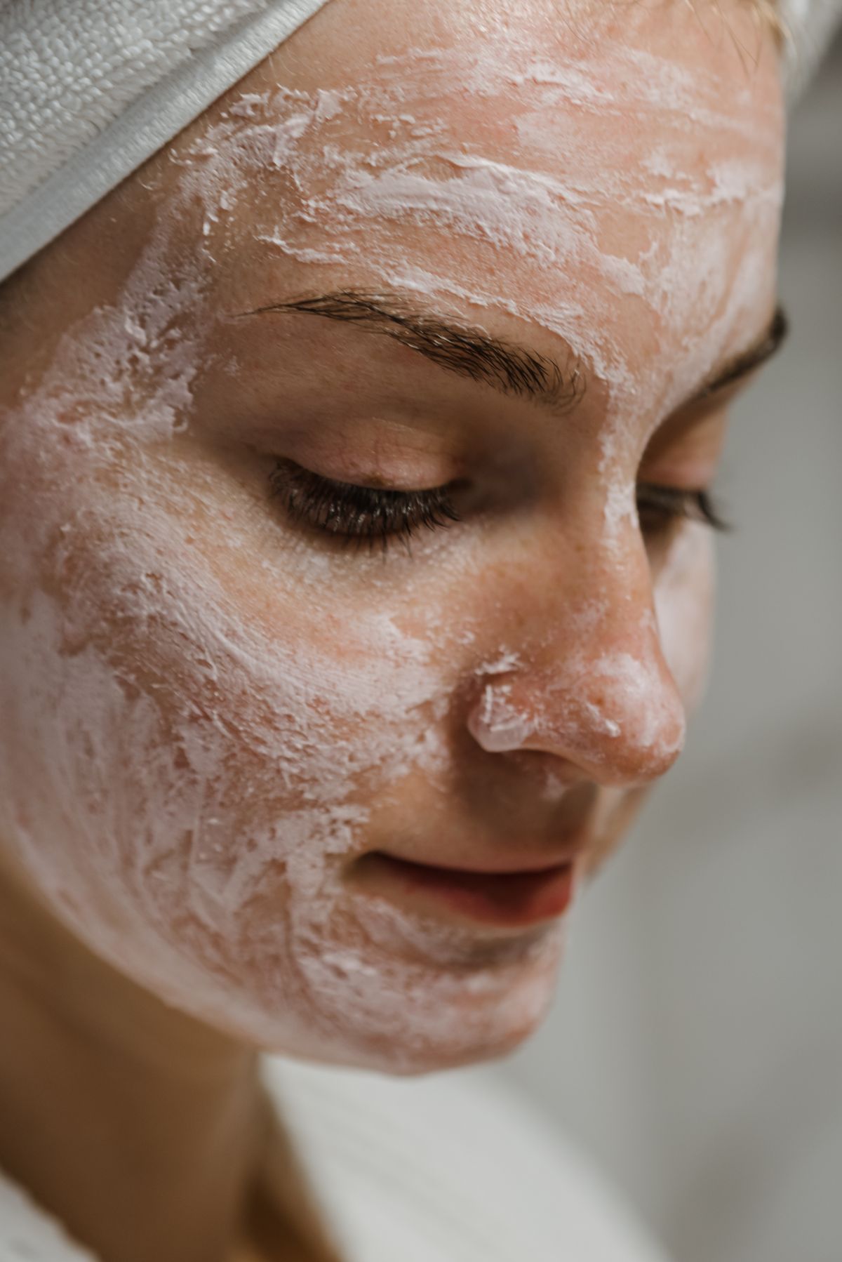 Mujer aplicando una mascarilla facial de arcilla