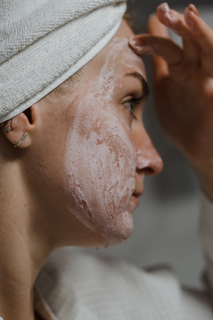 A Woman Putting Clay Mask On Her Face 