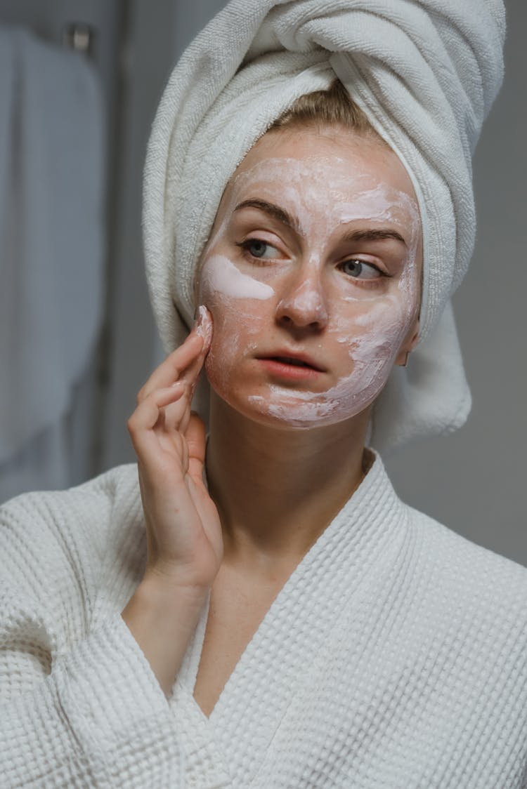 A Woman Applying Facial Cream On Face