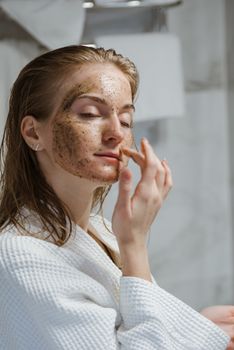 一名成年女性在浴室里用咖啡洗面奶进行自然的护肤