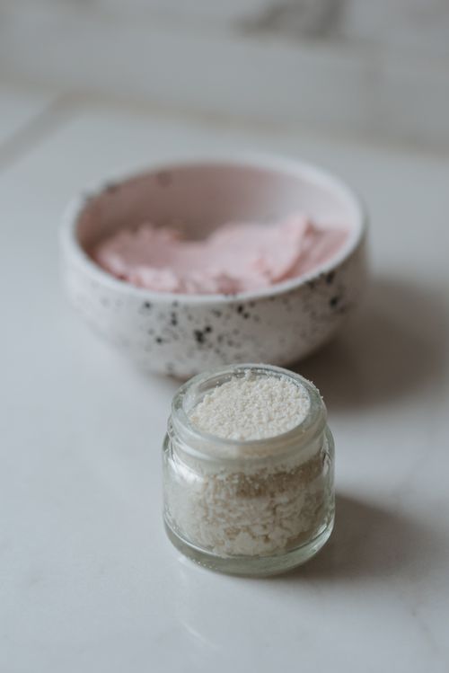 Free Close-up of natural skincare products featuring a lip scrub in a glass jar and a creamy mixture in a ceramic bowl. Stock Photo