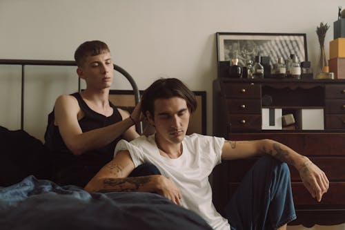 Free Gay Couple Sitting Together on the Bed  Stock Photo