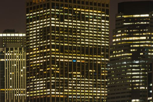 Illuminated skyscrapers in New York City at night, showcasing urban architecture.