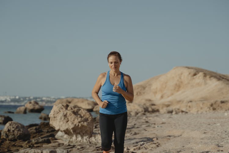 A Woman In Blue Activewear Jogging Outside