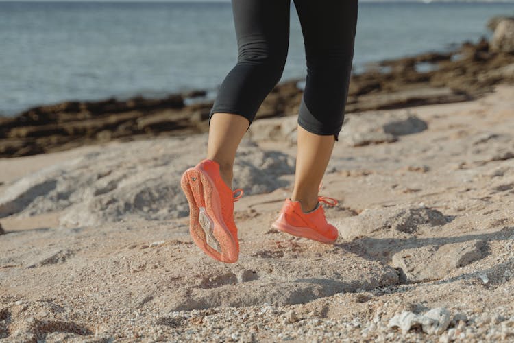 A Woman In Black Leggings And Orange Shoes