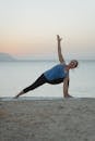 日出时分，一名女子在海滩上练习瑜伽，享受健身的乐趣与宁静