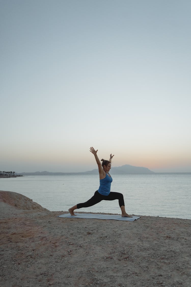 Woman Doing Yoga On The Beach